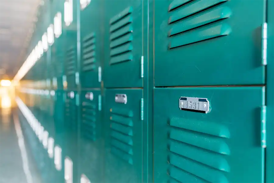 Green,Metal,Lockers,Along,A,Nondescript,Hallway,In,A,Typical