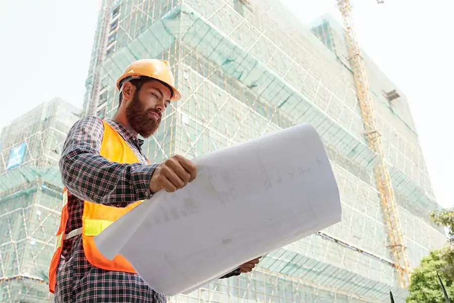 Professional,Civil,Engineer,In,Hard,Hat,Examining,Blueprint,Of,Building